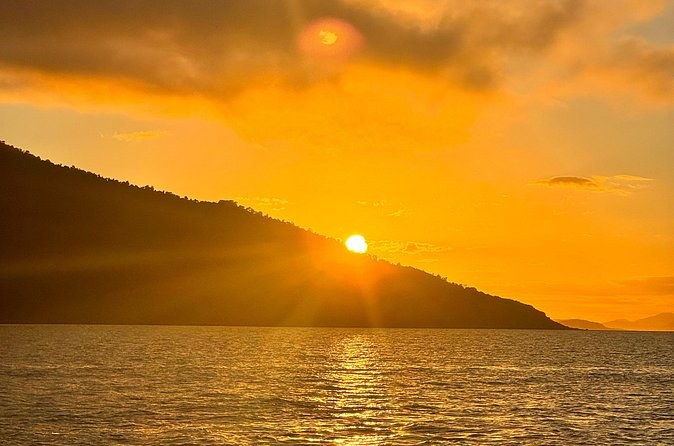 The sun going down behind the hills, seen from a boat on the water